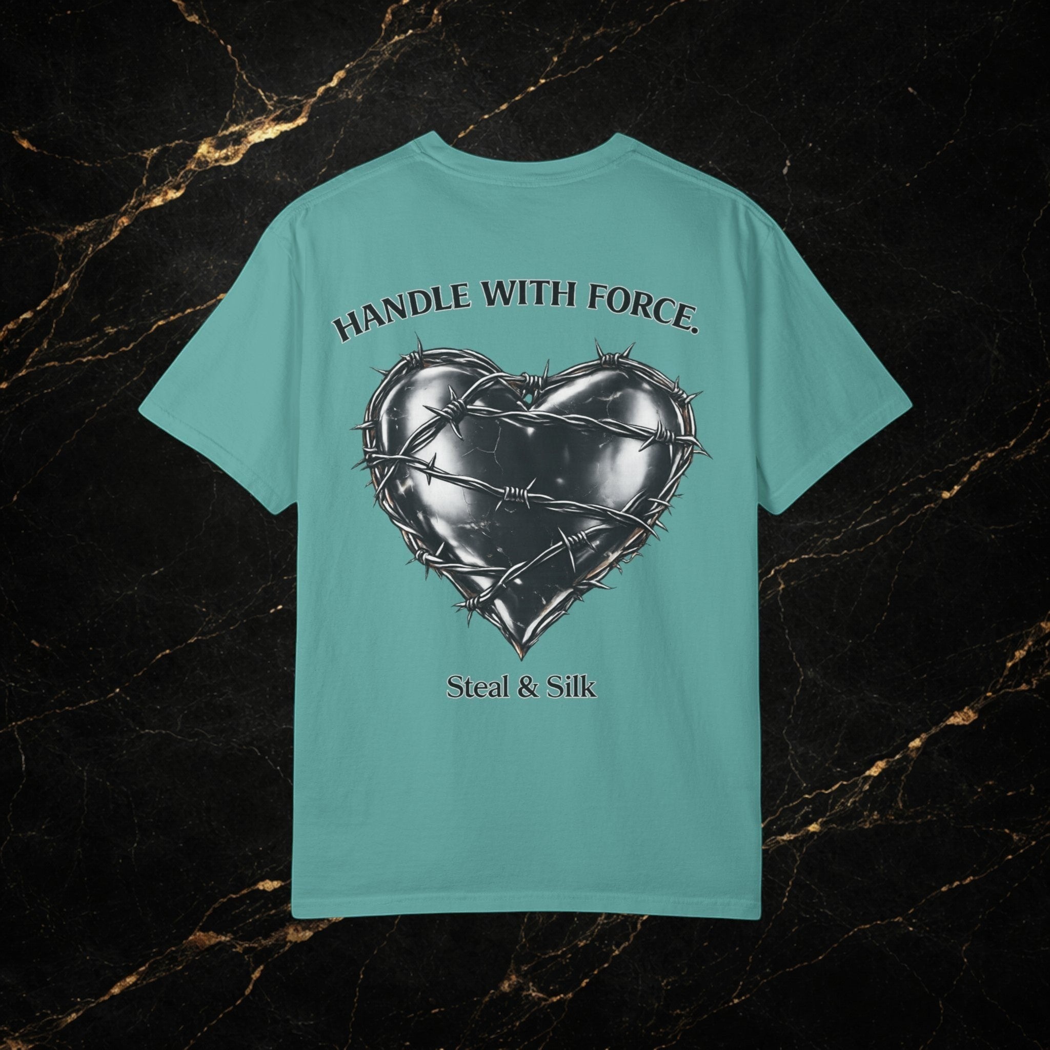 Steal & Silk teal cotton t-shirt with a barbed wire heart graphic and "Handle With Force" text.