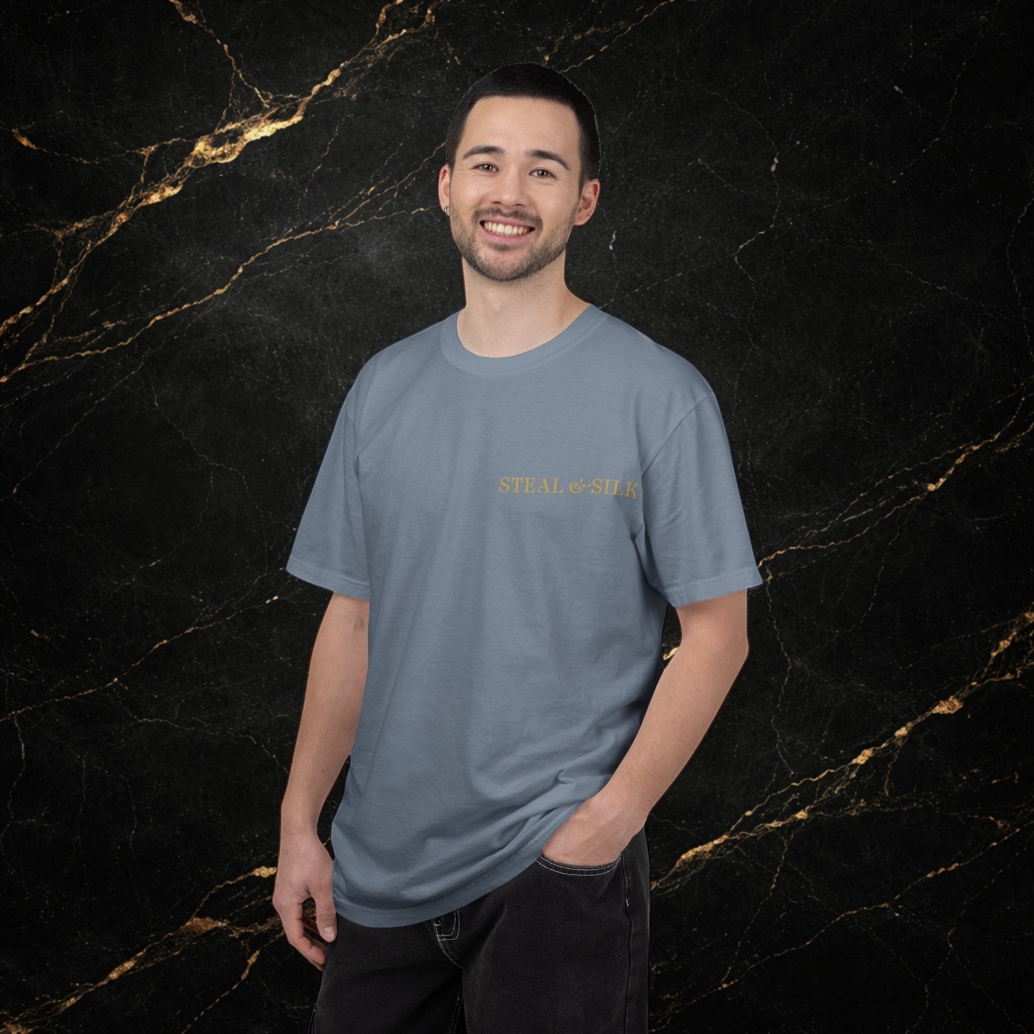Steal & Silk blue cotton t-shirt with gold 'Handle With Force' heart graphic on chest. Model is wearing dark jeans.