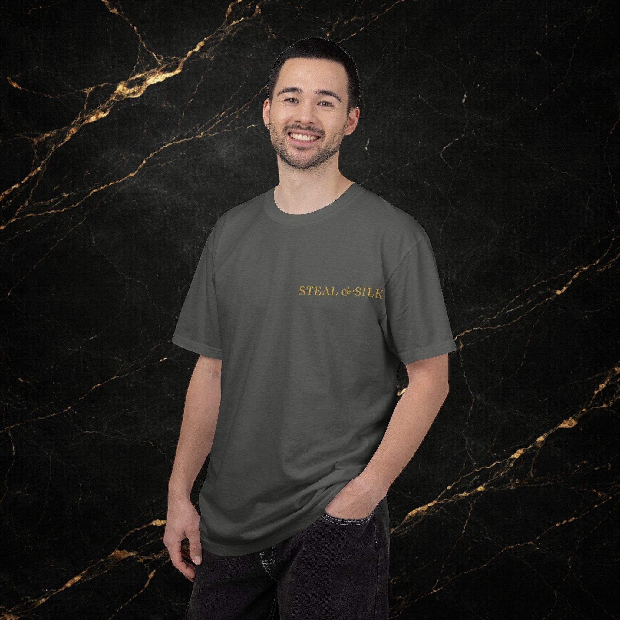 Steal & Silk dark grey cotton t-shirt with gold embroidered logo on chest, worn by a man.