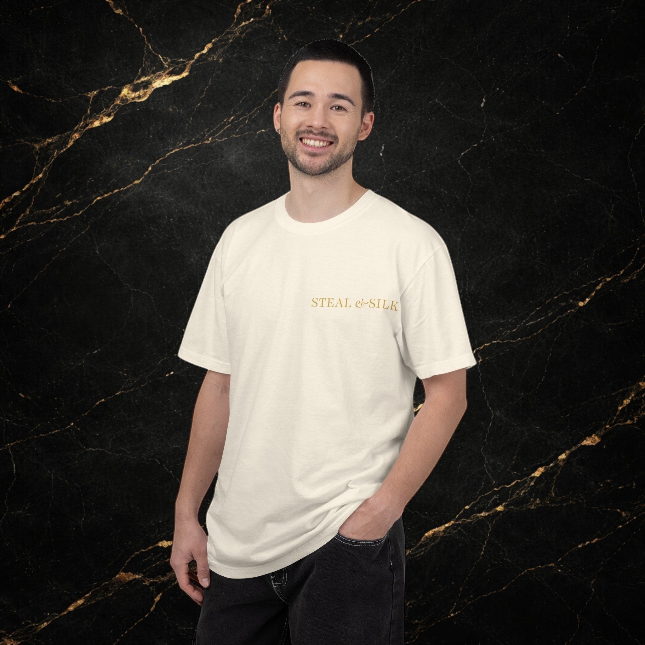 Steal & Silk cream cotton t-shirt with gold "Handle With Force" heart graphic on chest. Model wearing black jeans.