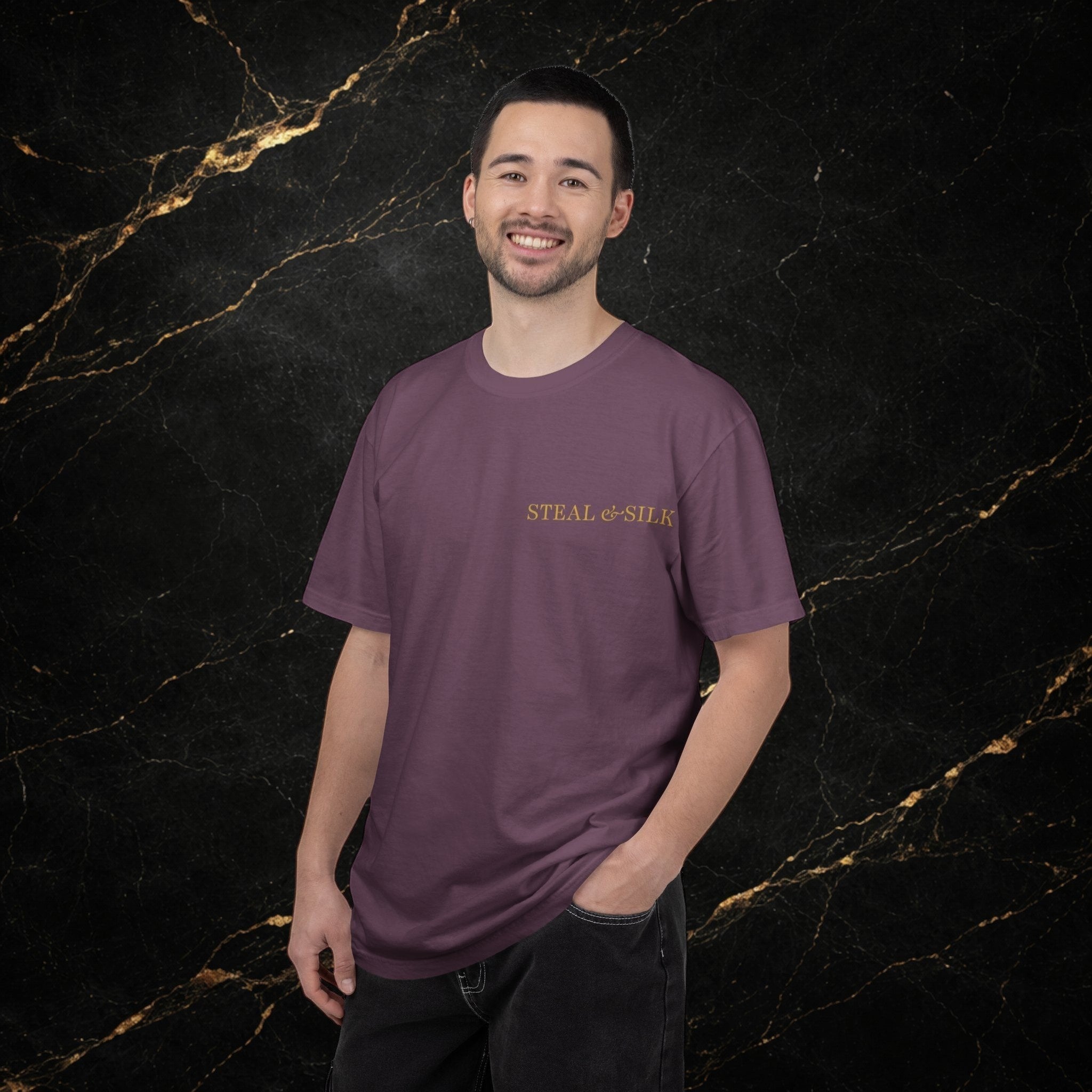 Steal & Silk plum purple cotton t-shirt with embroidered logo on chest. Model is wearing dark jeans.
