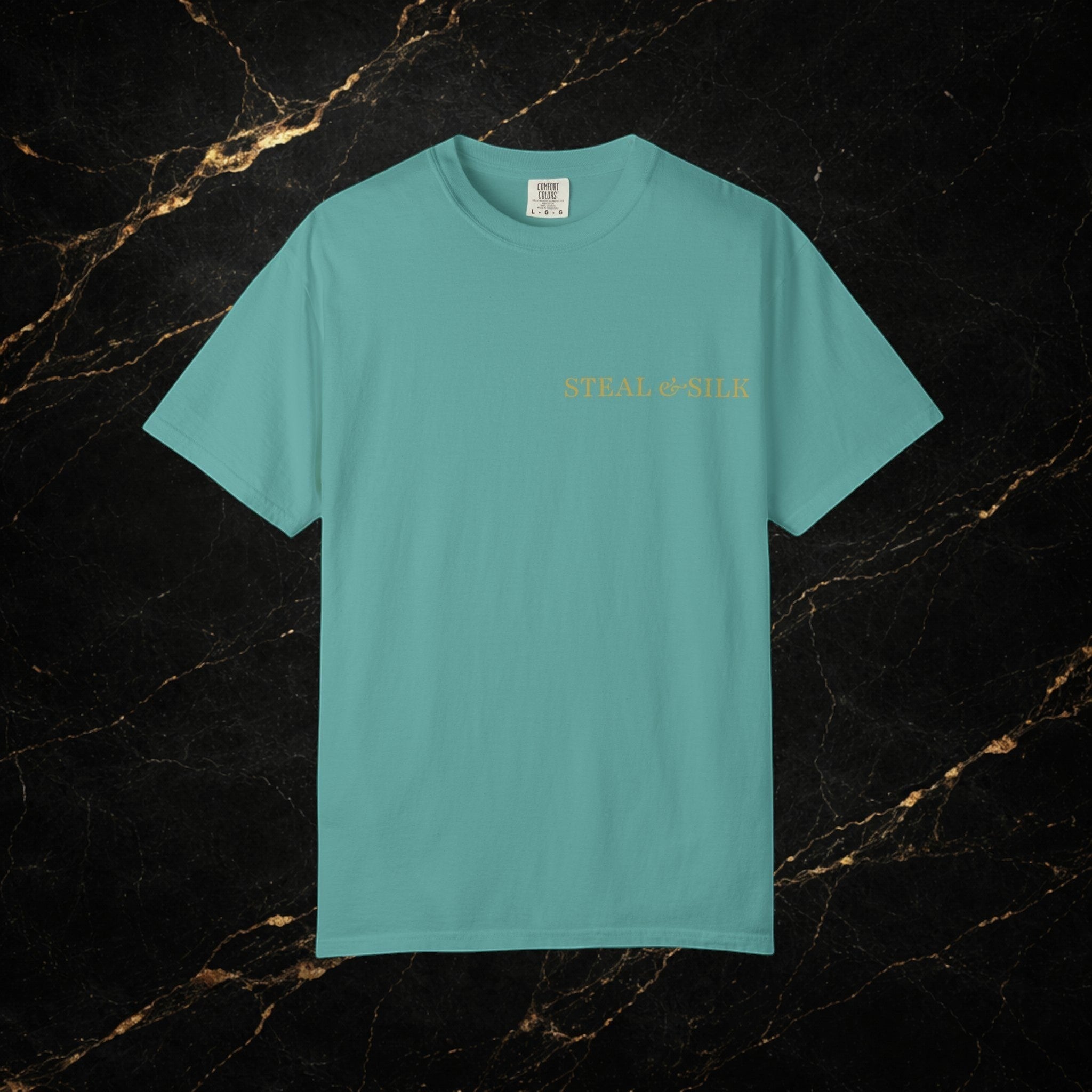 Steal & Silk teal cotton t-shirt with embroidered heart graphic and brand name on chest.