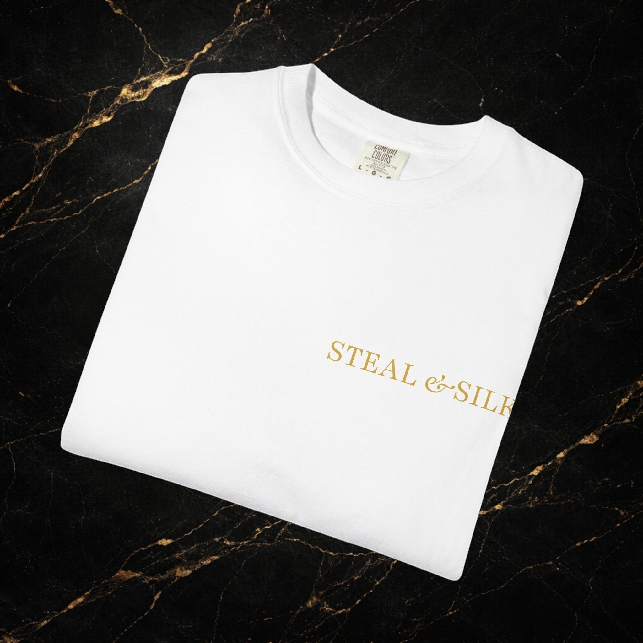White cotton t-shirt with gold Steal & Silk logo on the chest. Modern fit, premium fabric.