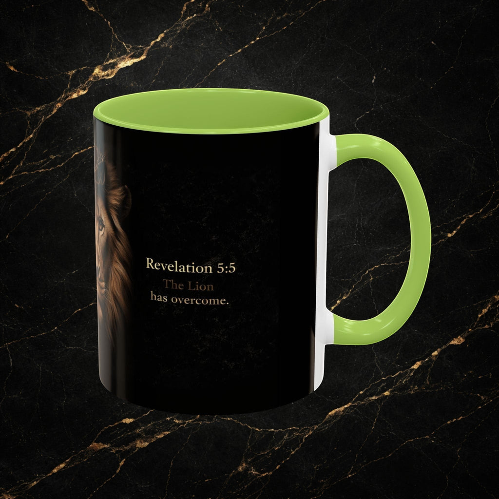 Steel & Silk black ceramic mug with a lion graphic and "Revelation 5:5 The Lion has overcome." text. Features a bright green handle and interior.